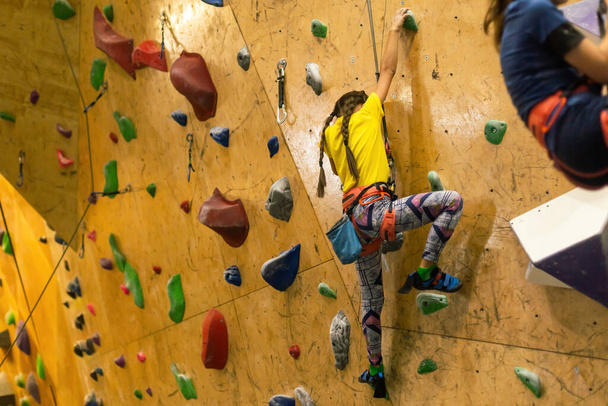 meisje een rotswand indoor klimmen. - Foto, afbeelding