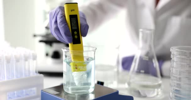 Científico utiliza solución química y prueba de laboratorio de calidad del agua o medidor de pH en el laboratorio. Investigación sobre el agua y científica - Imágenes, Vídeo