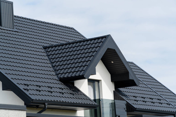 The roof of a modern new house. Tiled covering of building. Modern European house. - Photo, Image