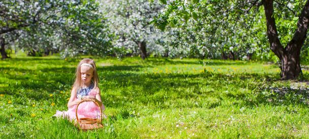 Чарівна маленька дівчинка розважається в квітковому саду яблуні в травні
 - Фото, зображення