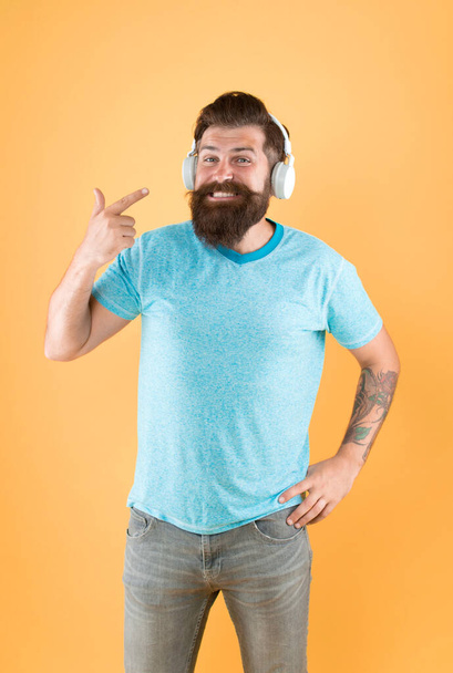 Bearded man listening music wireless gadget. Wireless headphones designed to deliver clean sound. Freedom going wireless offers you is unparalleled. Hipster happy using modern wireless headphones. - Foto, Bild