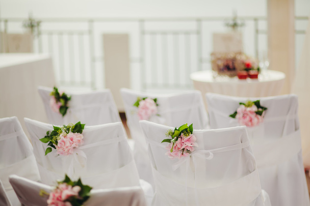 housses de chaises de mariage avec des fleurs roses
 - Photo, image