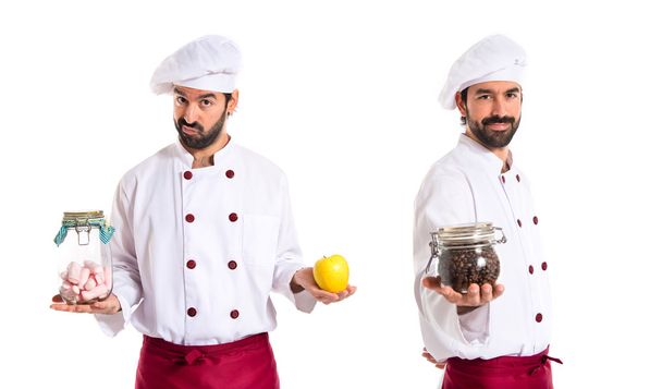 Chef in possesso di barattolo di vetro con dolci in una mano e mela in
  - Foto, immagini