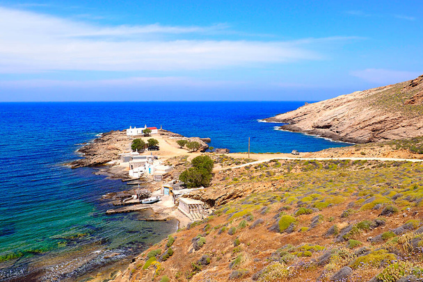 漁港があるメルキア・ビーチとエーゲ海の中心に位置するキクラデス諸島の有名なギリシャの島、ミコノス島の北にある聖ニコラス礼拝堂 - 写真・画像