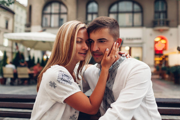 Couple aimant se détendre dans la vieille ville de Lviv portant des chemises ukrainiennes nationales traditionnelles. Les jeunes mariés passent du temps ensemble sur la place - Photo, image