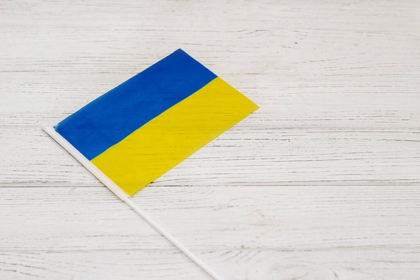 Ukrainian blue yellow flag on a wooden white background. - Foto, afbeelding