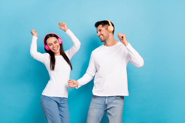 Photo of two carefree cheerful people enjoy new single dancing isolated on blue color background. - Foto, afbeelding