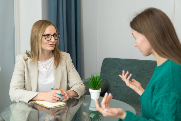 Psychologist makes a social survey of the reference group. Professional is talking to a client. Informal communication at the interview, business consultant writes notes in a notebook. - Photo, image