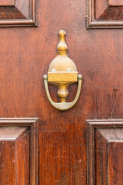 Europe, Portugal, Porto, Vila Nova de Gaia. Brass knocker on a wooden door. - Photo, image