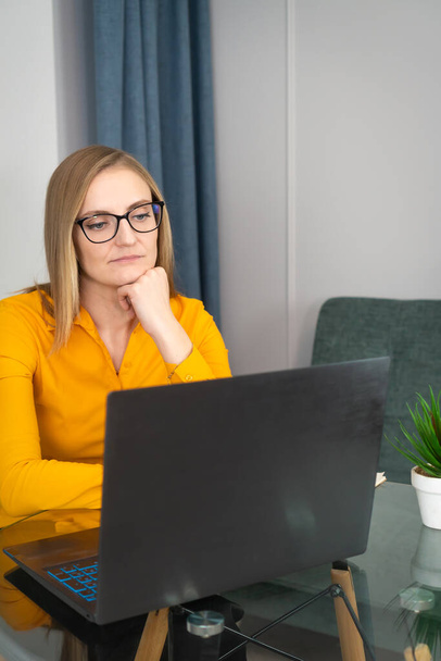 Psychologist or coach conducts an online consultation in a home office, remote work of a home psychologist online. Professional woman with glasses. Consults with a psychologist online from a laptop. - Фото, изображение