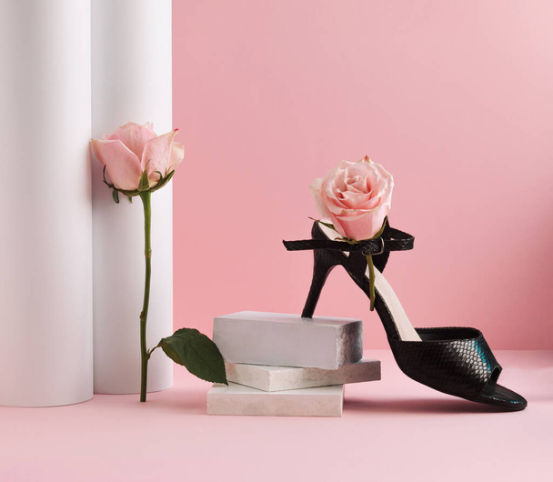 Black high heels and pink rose flowers on pastel pink background. Environmental protection and sustainability idea. Minimal sustainable fashion concept. - Foto, Imagem