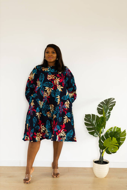 Smiling confident african american young woman wears stylish dress standing over white background in room - inclusion and diversity - Fotografie, Obrázek