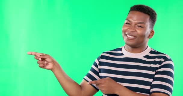 Happy, Green screen and black man pointing at mockup space isolated in a studio background with a smile. Excited, advertising and portrait of male showing brand placement, promotion or sale. - Footage, Video