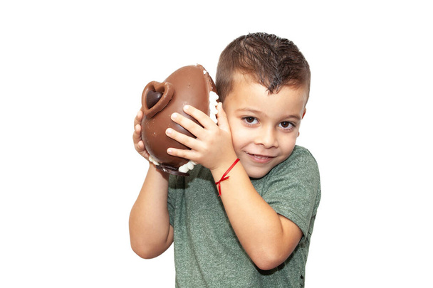 happy little boy with easter chocolate egg on light background - Foto, afbeelding