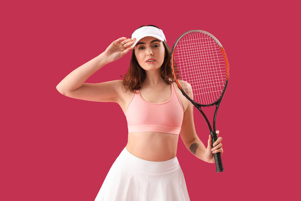 Mujer joven con raqueta de tenis sobre fondo rosa - Foto, imagen