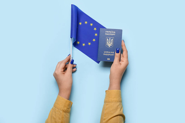 Γυναίκα με ουκρανικό διαβατήριο και σημαία της Ευρωπαϊκής Ένωσης σε μπλε φόντο - Φωτογραφία, εικόνα