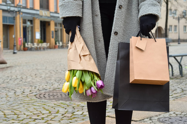 Mladá žena s kyticí tulipánů a nákupních tašek na ulici, detailní záběr - Fotografie, Obrázek