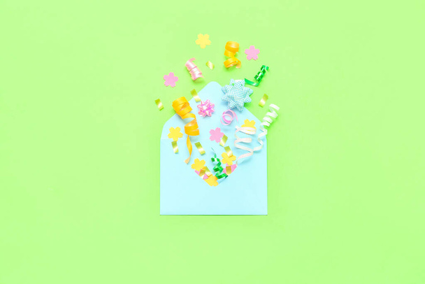 Composition with envelope and confetti on green background - Foto, imagen