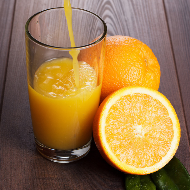fresh orange juice pouring into glass on the table - Foto, immagini