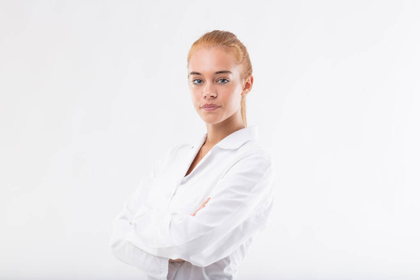 Young female researcher or scientist in a white lab coat, with blonde hair and blue eyes, hoping to contribute to improving the world with her dedication, sharing knowledge, gaining insights, and achi - 写真・画像