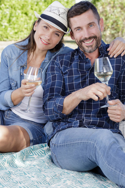 a woman and man enjoying some wine outdoors - Fotoğraf, Görsel