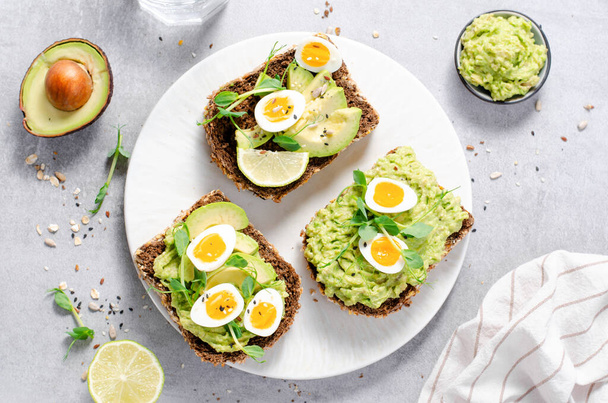 Avocado and Quail Egg Toasts, Healthy Snack or Breakfast on Bright Background - Fotoğraf, Görsel