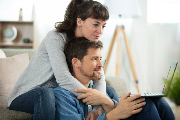 couple watching online laptop content relaxed at home - Photo, Image