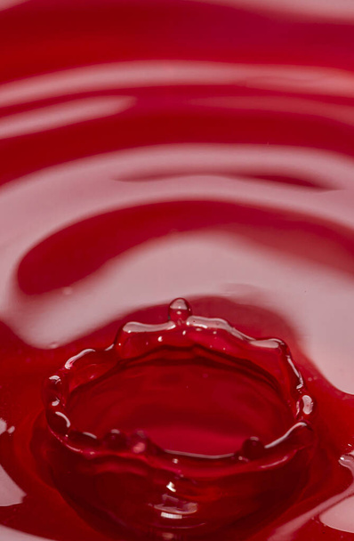 Fotografie kruhů na vodě z padající kapky vody. Červené abstraktní pozadí. Kvalitní fotografie - Fotografie, Obrázek