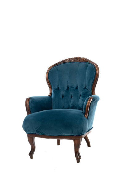 Old vintage velvet armchair with carved brown wooden frame and blue textile upholstery isolated on white background. - Foto, afbeelding