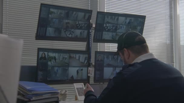 Ochroniarz monitoruje kamery CCTV na komputerach i tabletach cyfrowych. Oprogramowanie wyświetlające nagrania z kamer z rozpoznawaniem twarzy na ekranach. Nowoczesna ochrona. Pojęcie bezpieczeństwa socjalnego. - Materiał filmowy, wideo