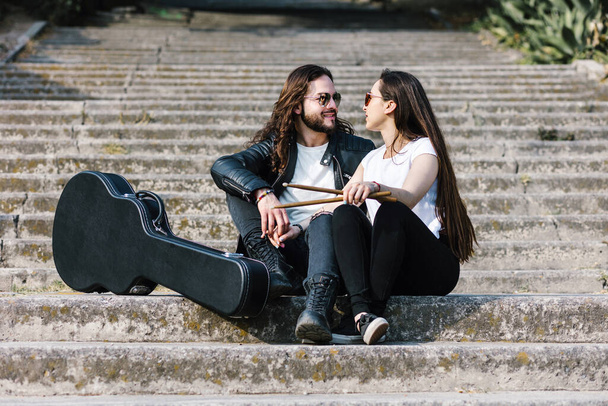 young latin couple man and woman in rock and roll style and playing guitar in the street in Mexico Latin America - Φωτογραφία, εικόνα