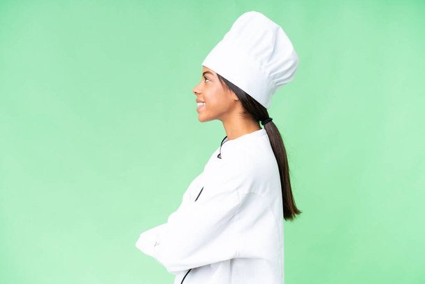 Jonge Afro-Amerikaanse chef-kok over geïsoleerde chroma belangrijkste achtergrond in laterale positie - Foto, afbeelding