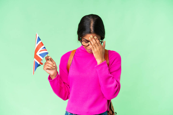 若いアフリカ系アメリカ人女性は疲れや病気の表情で孤立したクロマキーの背景に英国の旗を持っています - 写真・画像