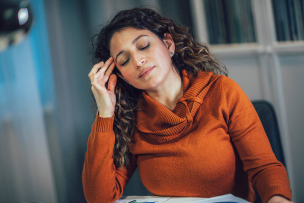 Молодая женщина страдает от головной боли работы на ноутбуке в домашнем офисе. - Фото, изображение