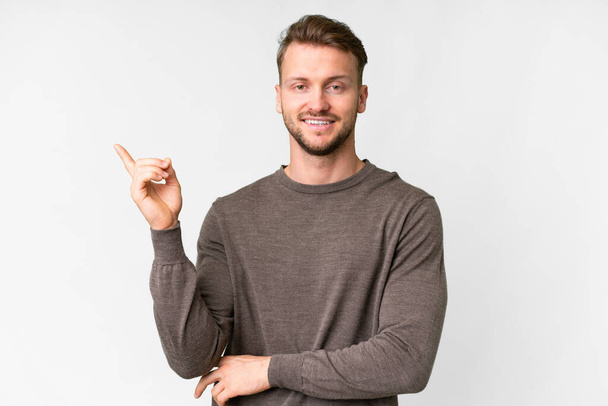 Young handsome caucasian man over isolated white background happy and pointing up - Valokuva, kuva