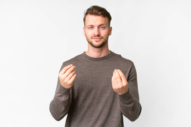 Young handsome caucasian man over isolated white background making money gesture but is ruined - Foto, Imagem