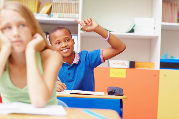 Ha la risposta. Giovane ragazzo afro-americano alzando la mano in classe per rispondere a una domanda - copyspace - Foto, immagini