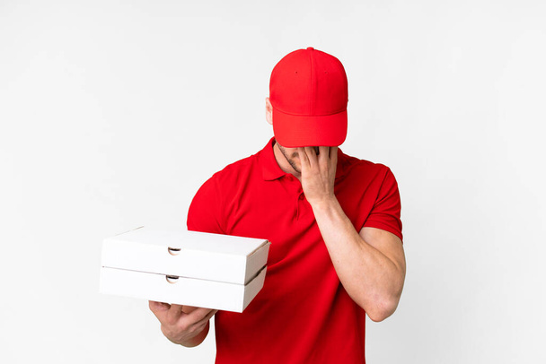 Pizza teslimatçısı üniformalı adam izole edilmiş beyaz arka planda pizza kutuları alıyor yorgun ve hasta bir ifadeyle - Fotoğraf, Görsel