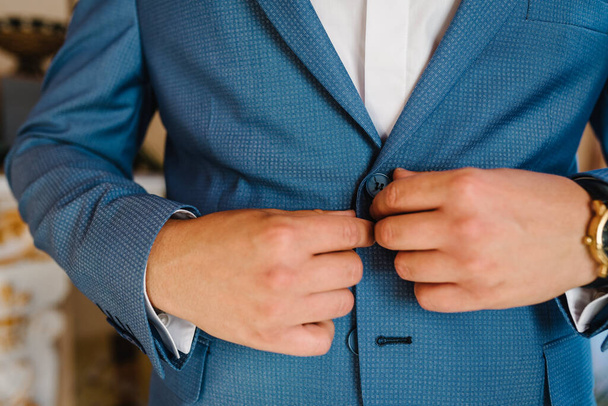 Close-up men's hands fastens the buttons. The groom in a suit, shirt. stylish classic menswear. A part businessman prepares in the morning for a business day or a wedding. - Φωτογραφία, εικόνα