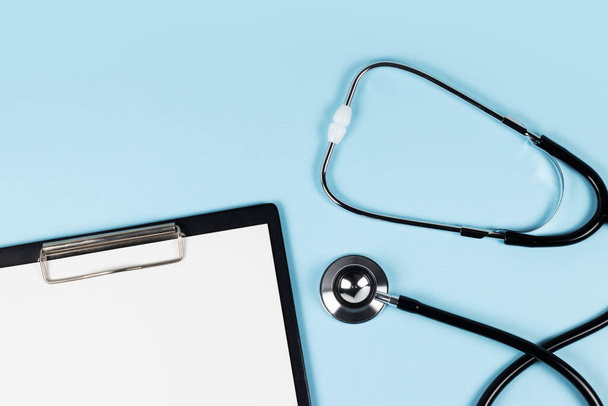 blank clipboard with modern stethoscope, space for messages. - Foto, afbeelding