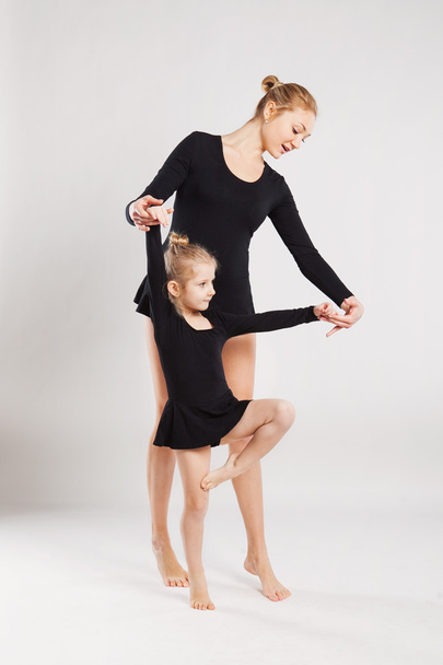 Woman teaching child to dance. mother and daughter gymnastics - 写真・画像