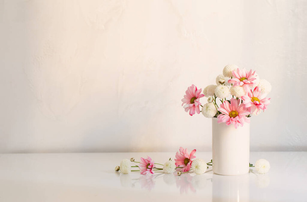белый и розовый хризантемы в вазе на белом фоне - Фото, изображение