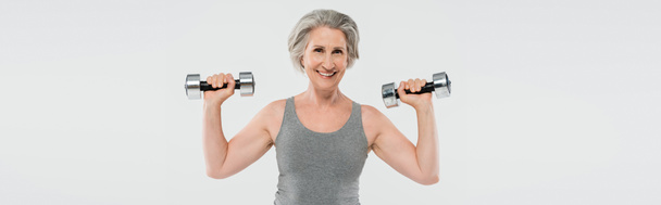 femme âgée ravie avec des cheveux gris exercice avec haltères isolé sur gris, bannière   - Photo, image