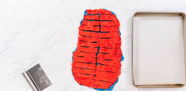 Flat lay. Rolling red and blue bread dough to bake patriotic cinnamon twists. - Photo, Image