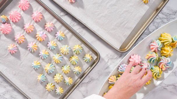 Step by step. Flat lay. Freshly baked unicorn meringue cookies on a baking sheet with a parchment paper. - Valokuva, kuva