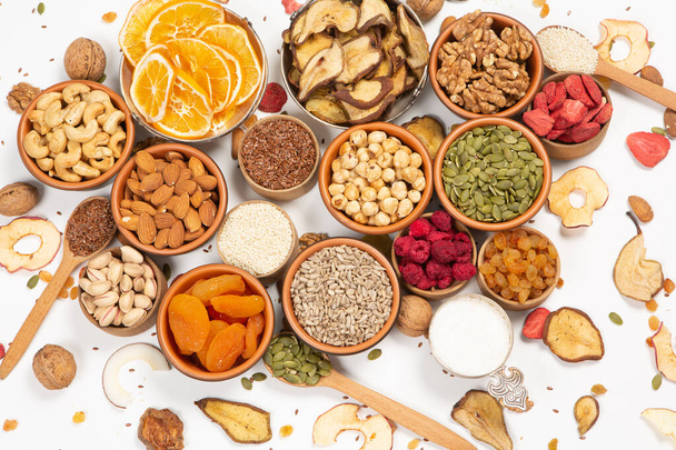 Healthy vegetarian food concept. Assortment of dried fruits, nuts and seeds on white background. Top view. - Photo, Image