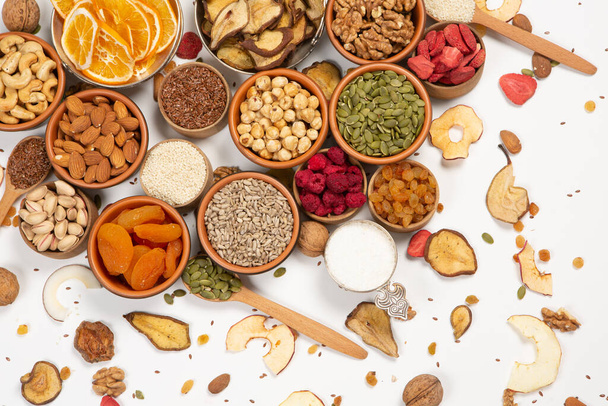 Healthy vegetarian food concept. Assortment of dried fruits, nuts and seeds on white background. Top view. - Photo, Image