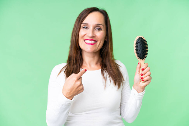 Middle age woman with hair comb over isolated chroma key background with surprise facial expression - Photo, image