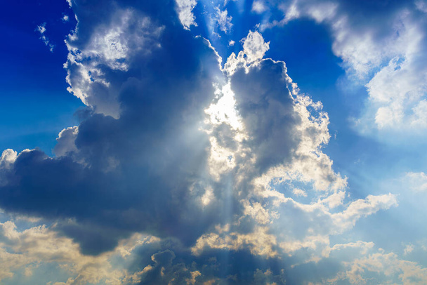 Сонячні промені прориваються крізь драматичні кумульні хмари. Погода змінюється від штормового до сонячного. Надія або концепція релігії
. - Фото, зображення