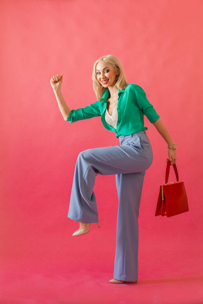 緑のシャツの女性とピンクの背景に買い物に行く赤いハンドバッグと青のジーンズ、ショッピング、販売、黒の金曜日のコンセプト - 写真・画像